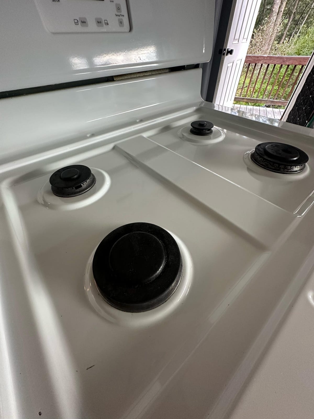 The same gas range with the tray and burners clean after deep cleaning