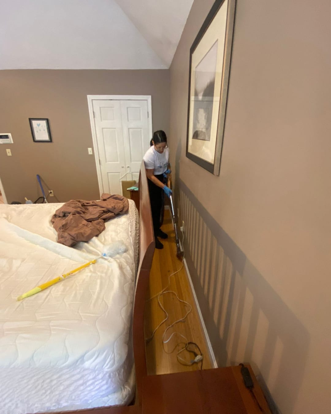 A bedroom with the bed made and surfaces cleared after a service