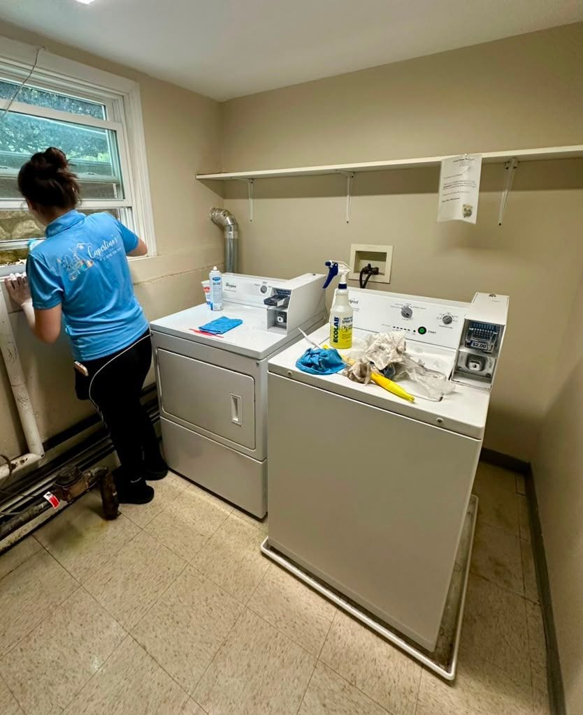 A team member working in a shared laundry room of a managed property