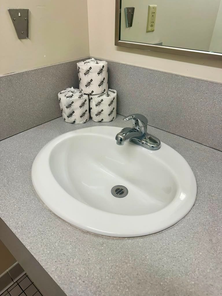 A cleaned restroom vanity with mirror and fixtures