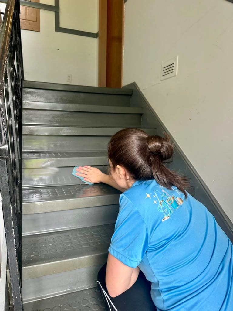 A team member cleaning the steps of an office stairwell