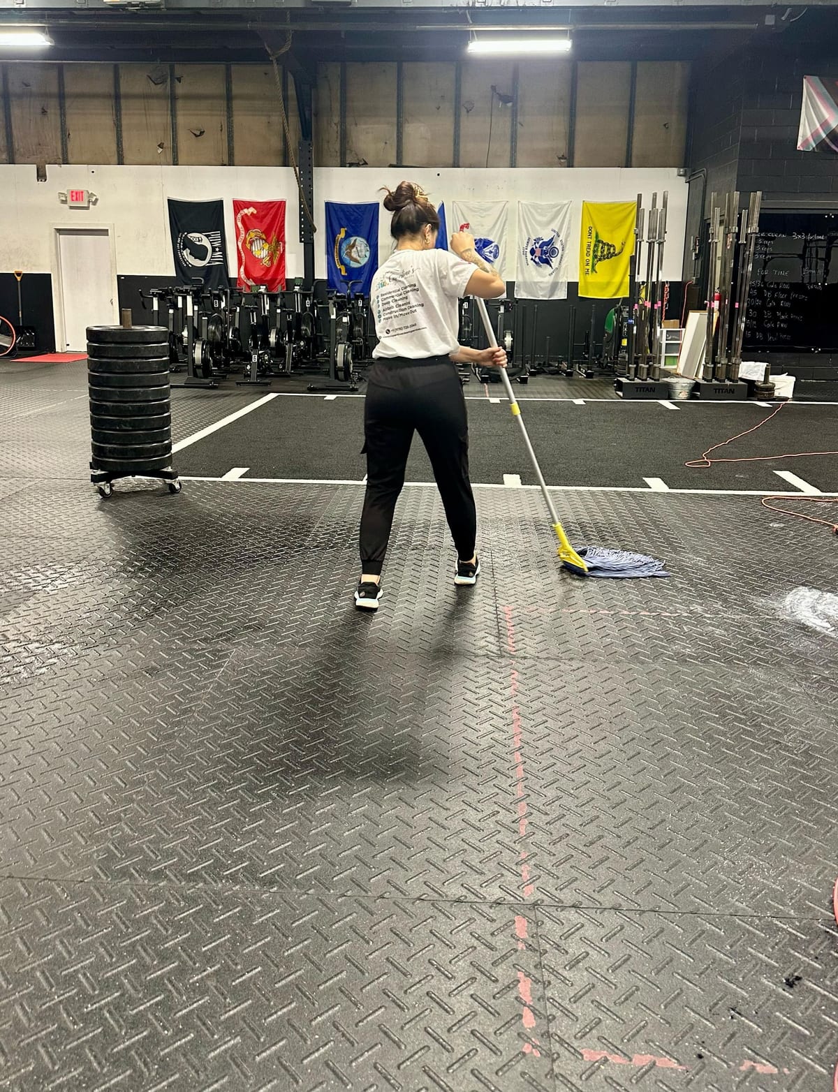 A Cupertino's team member mopping the floor of a fitness facility