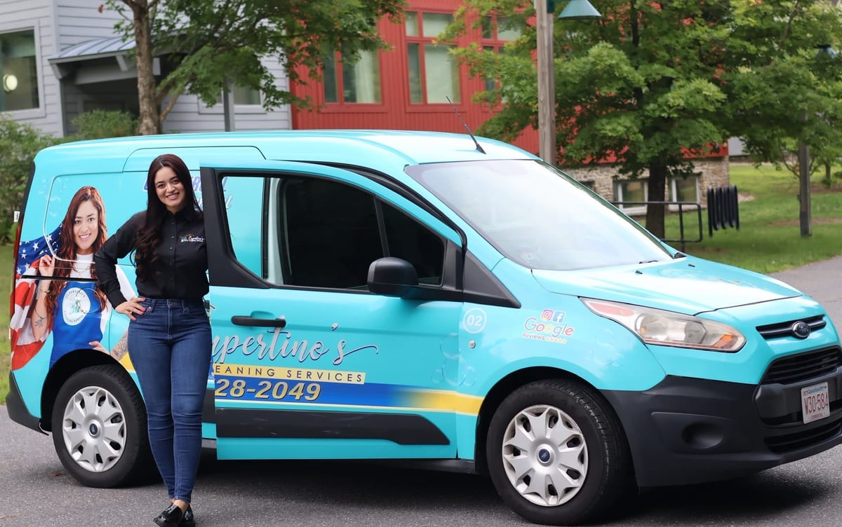 Karol Cupertino, founder, beside a branded Cupertino's Cleaning Services van